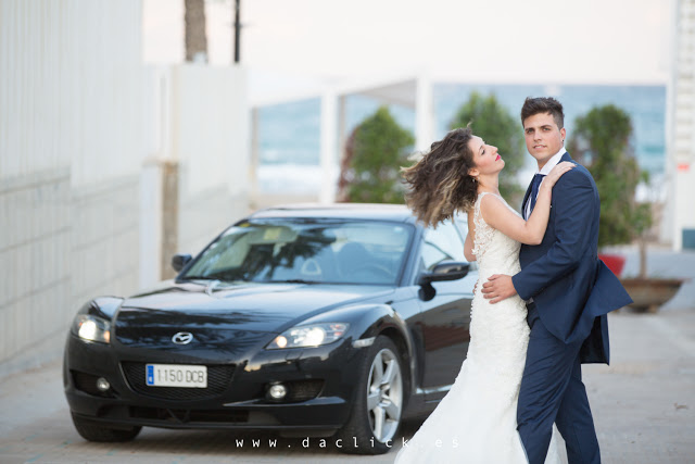 Pareja junto a un coche en el paseo marítimo