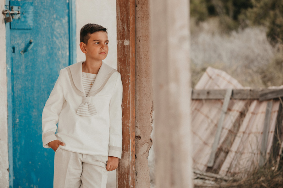 niño con traje de comunión en casa de marinero